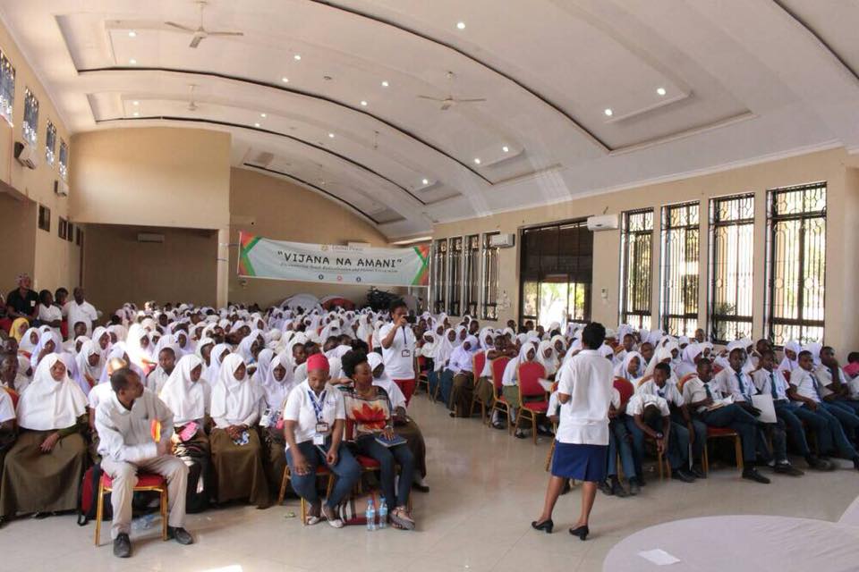 A speaker addresses a full room at the women's leadership summit