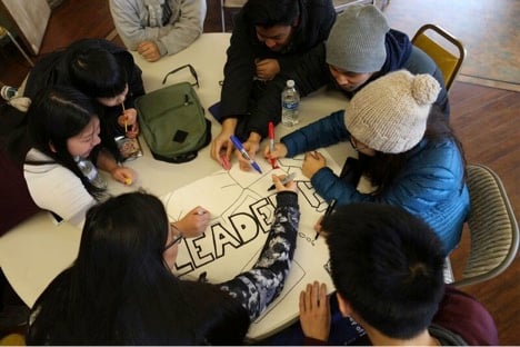 Volunteers design a poster to highlight leadership for local elementary school