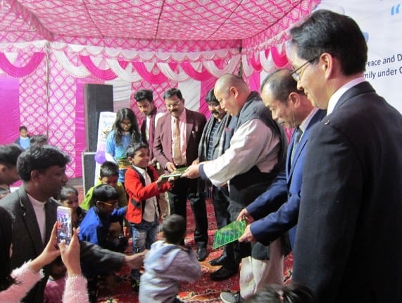 Smile Program organizers pass out books to children at the launching in December 2018