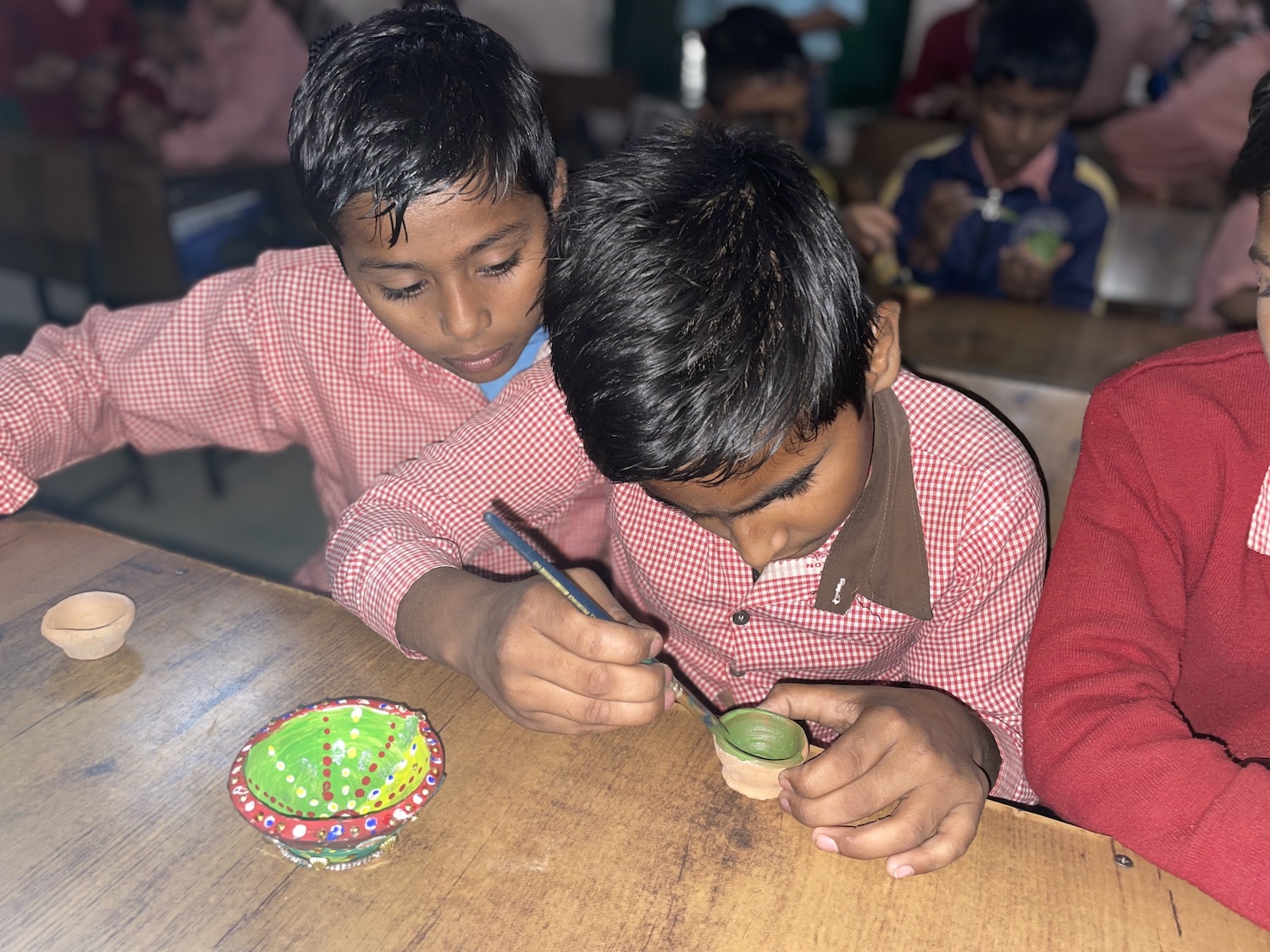 Children painting A group of children are working on a table in a classroom during the Festival of Lights, Diwali.