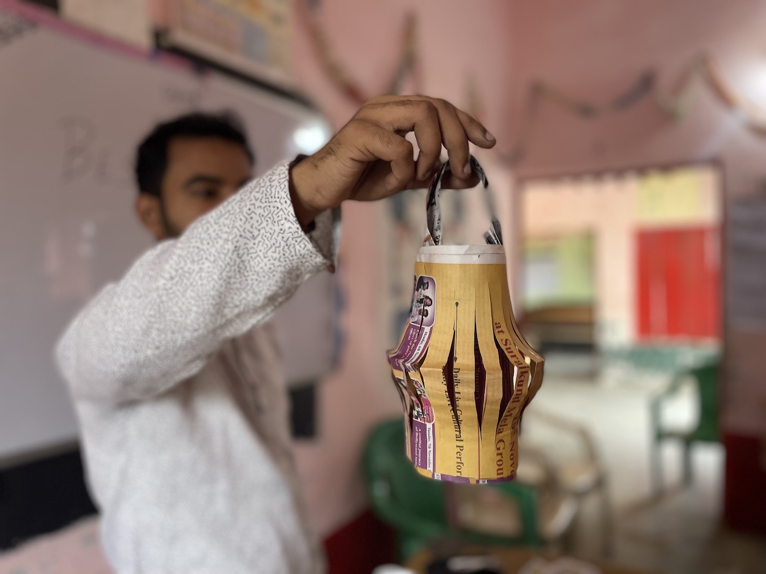 A man holding up a paper lantern during the Diwali festival, symbolizing the Festival of Lights and promoting sustainability.