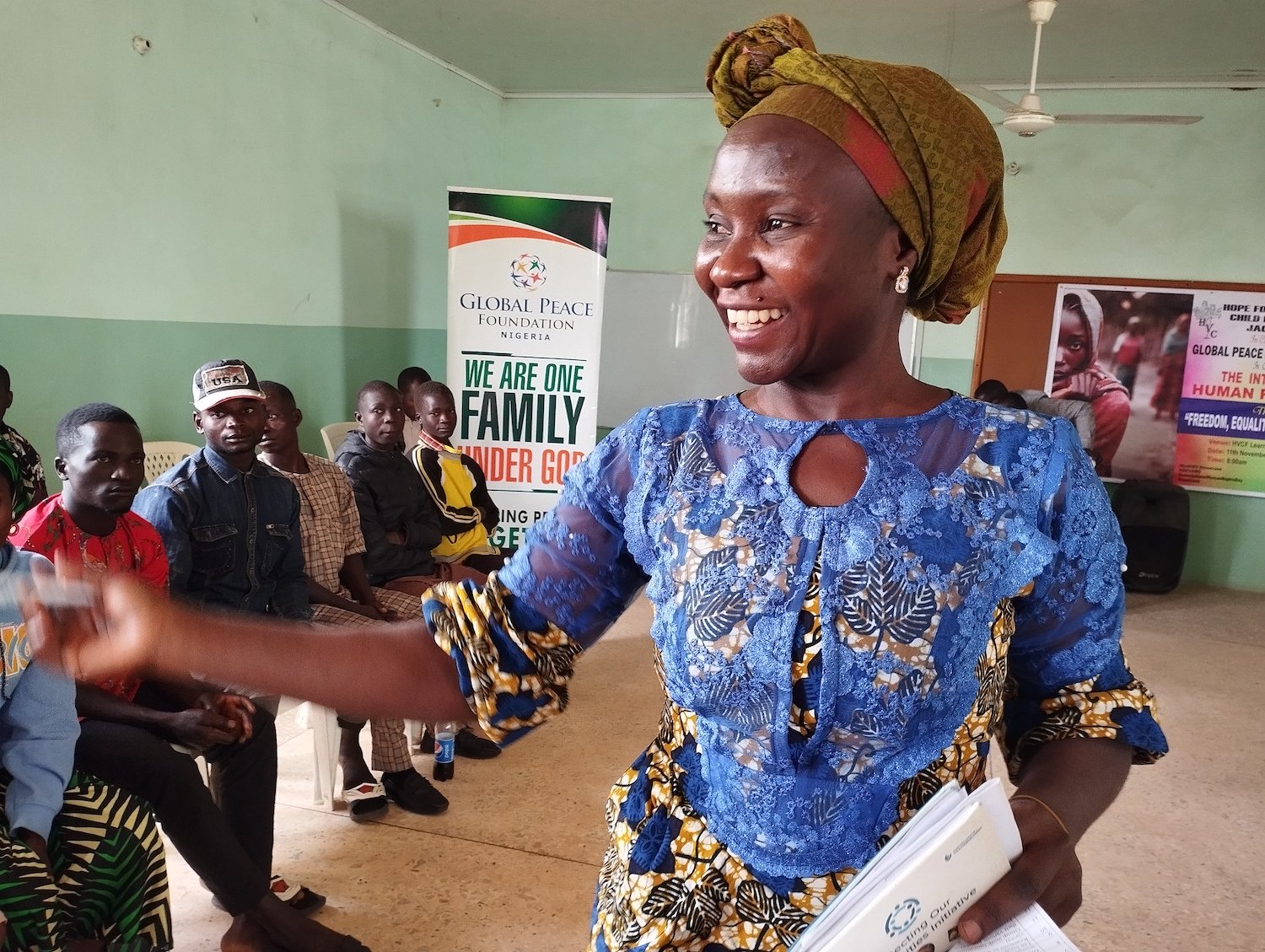 In Nigeria, Human Rights Day is commemorated with a woman standing in front of a group of people.