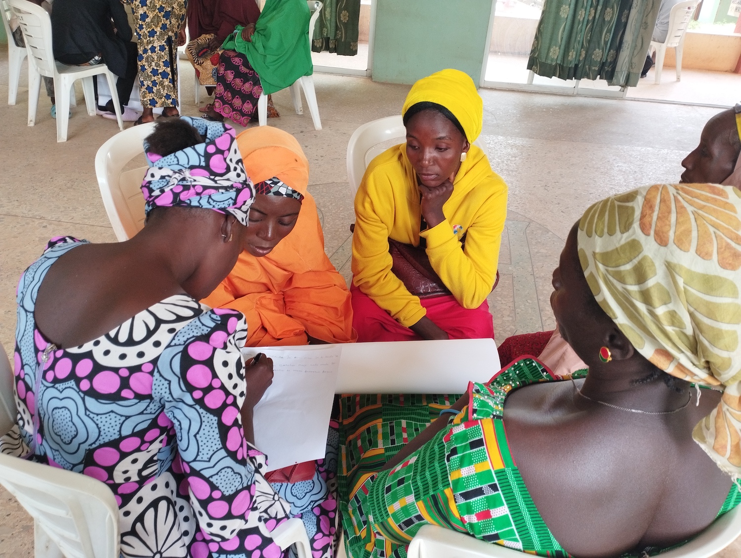 Group discussion 2 A group of women in Nigeria sitting around a table, commemorating Human Rights Day.