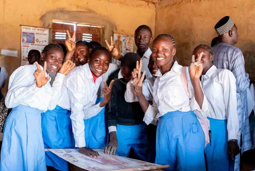 A group of school children from Bukuru posing for a photo as part of their community service project, promoting social cohesion.