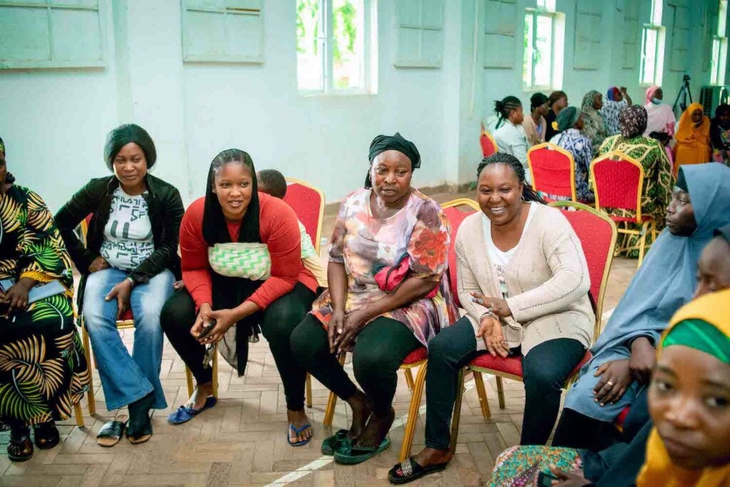 A group of women sitting on chairs in a room, taking part in a GPF Nigeria initiative for Economic Empowerment within Women's Cooperative Societies.