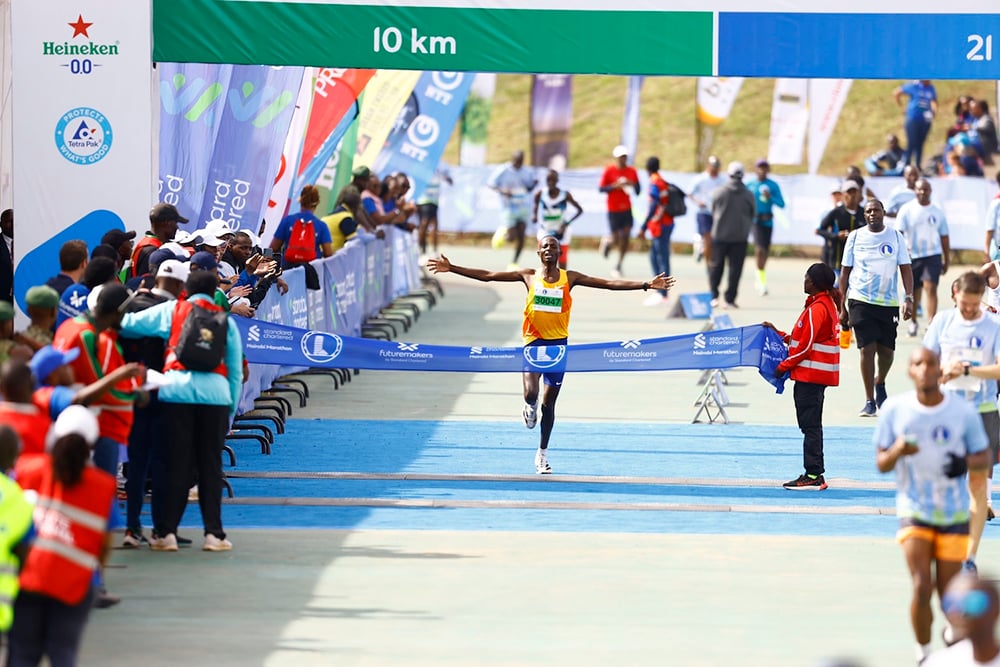 At the Standard Chartered Nairobi Marathon, a runner crosses the finish line with arms outstretched, surrounded by cheering spectators and race officials—thanks to partners like GPF Kenya for making this moment unforgettable.